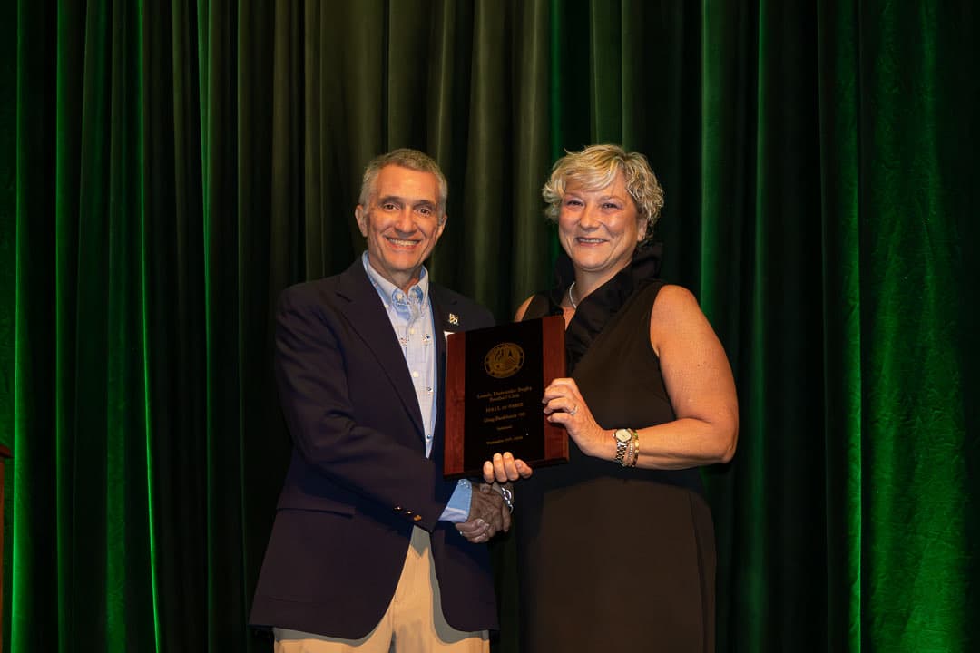 Maria Burkhardt accepting the plaque for Greg Burkhardt '90, inducted in memoriam