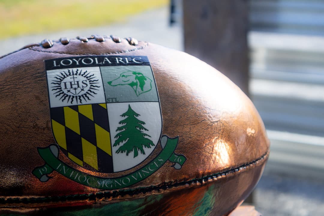 A bronzed rugby ball carrying the Loyola RFC crest